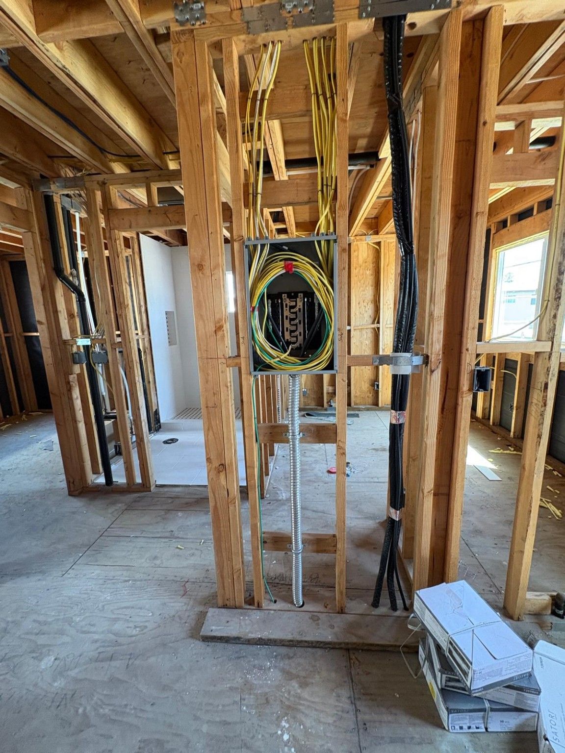 Open ADU interior framing with electrical wiring and a bathroom area beyond