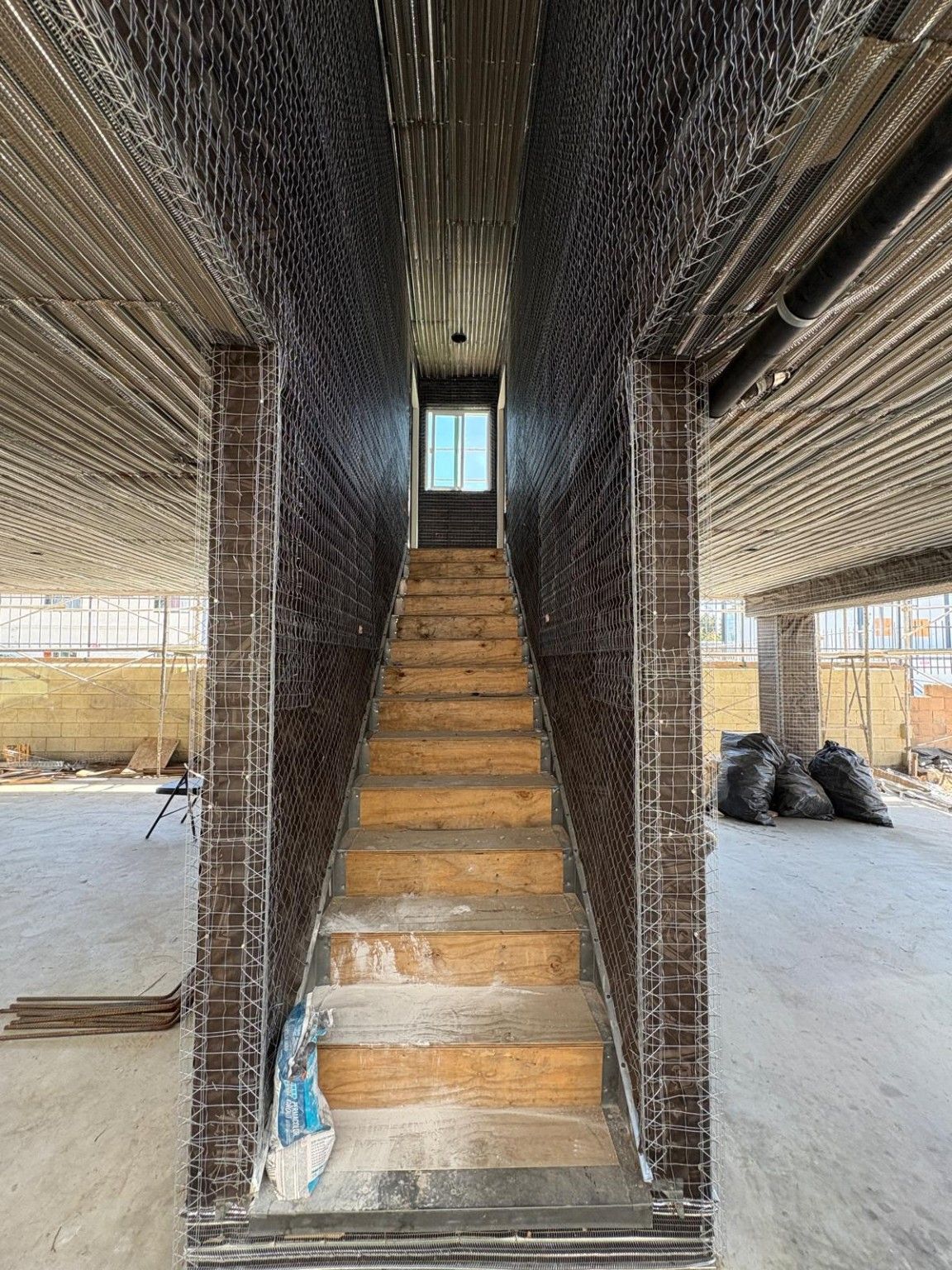 ADU construction progress showing the central stairway and ground-floor parking bays