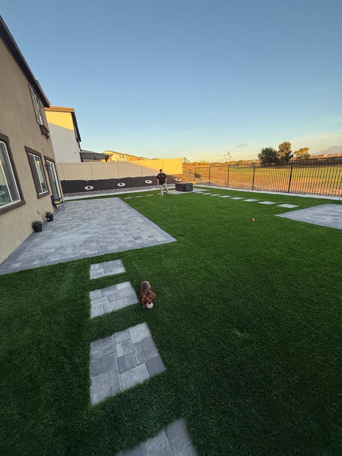 Remodeled backyard with pavers, turf, planter and decorative rocks