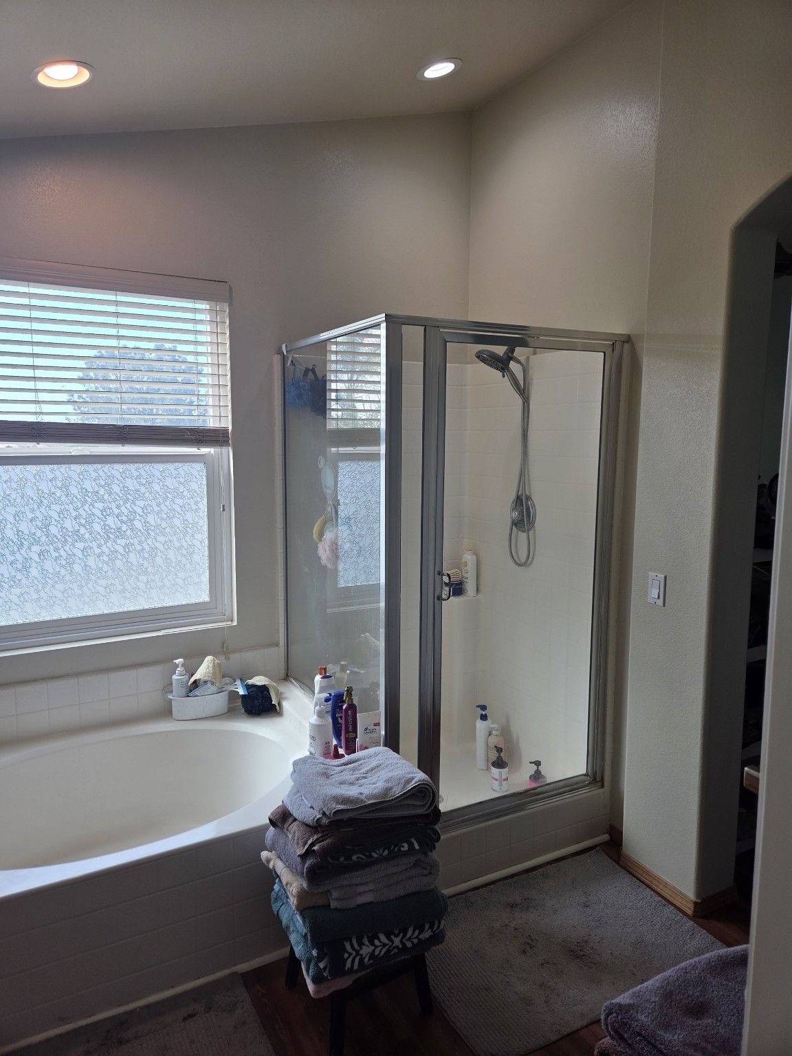 Original bathroom with a built-in tub, framed glass shower and carpet beside the tub.