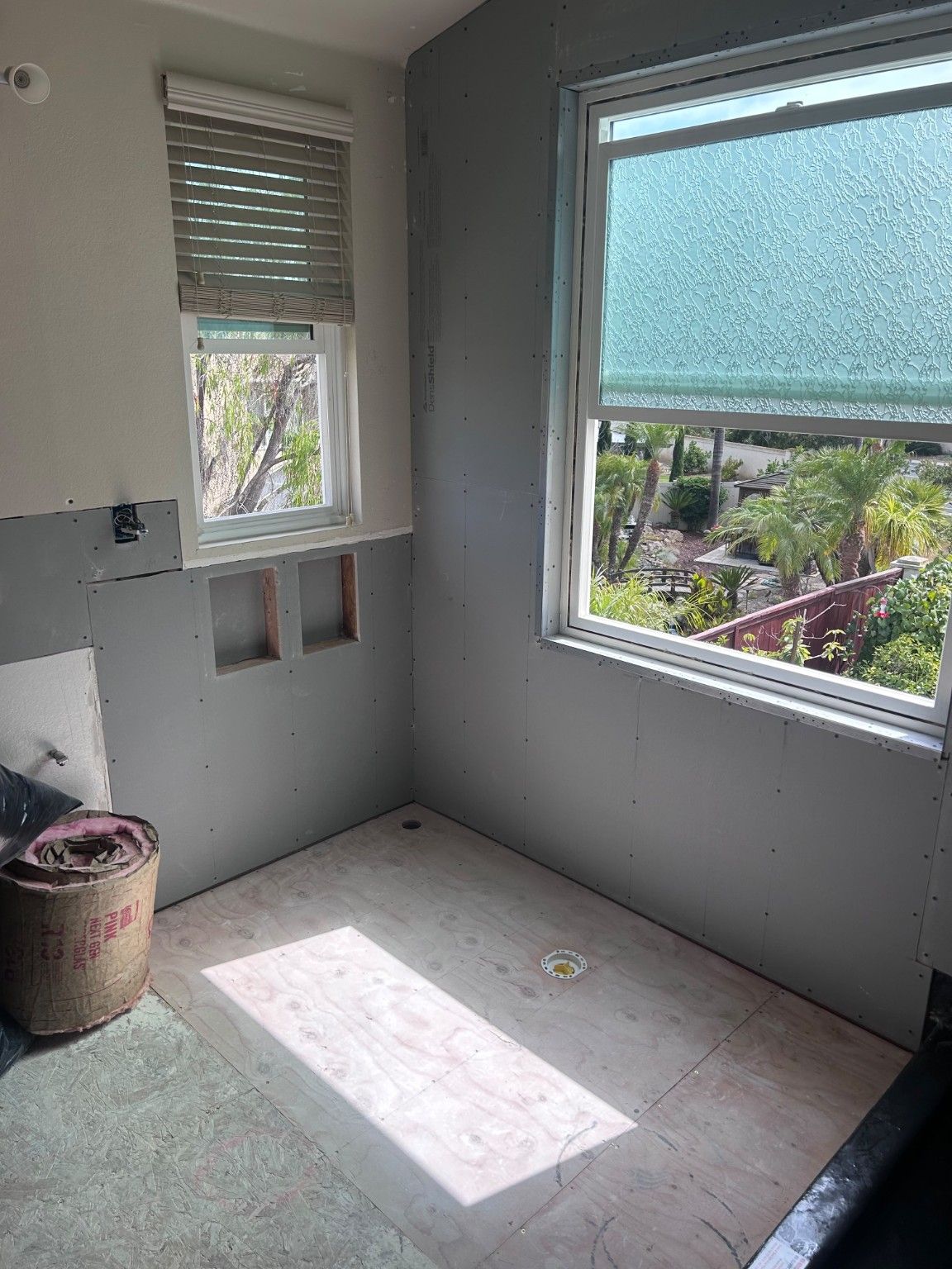 Wall panels and recessed openings around the bathroom windows during preparation.