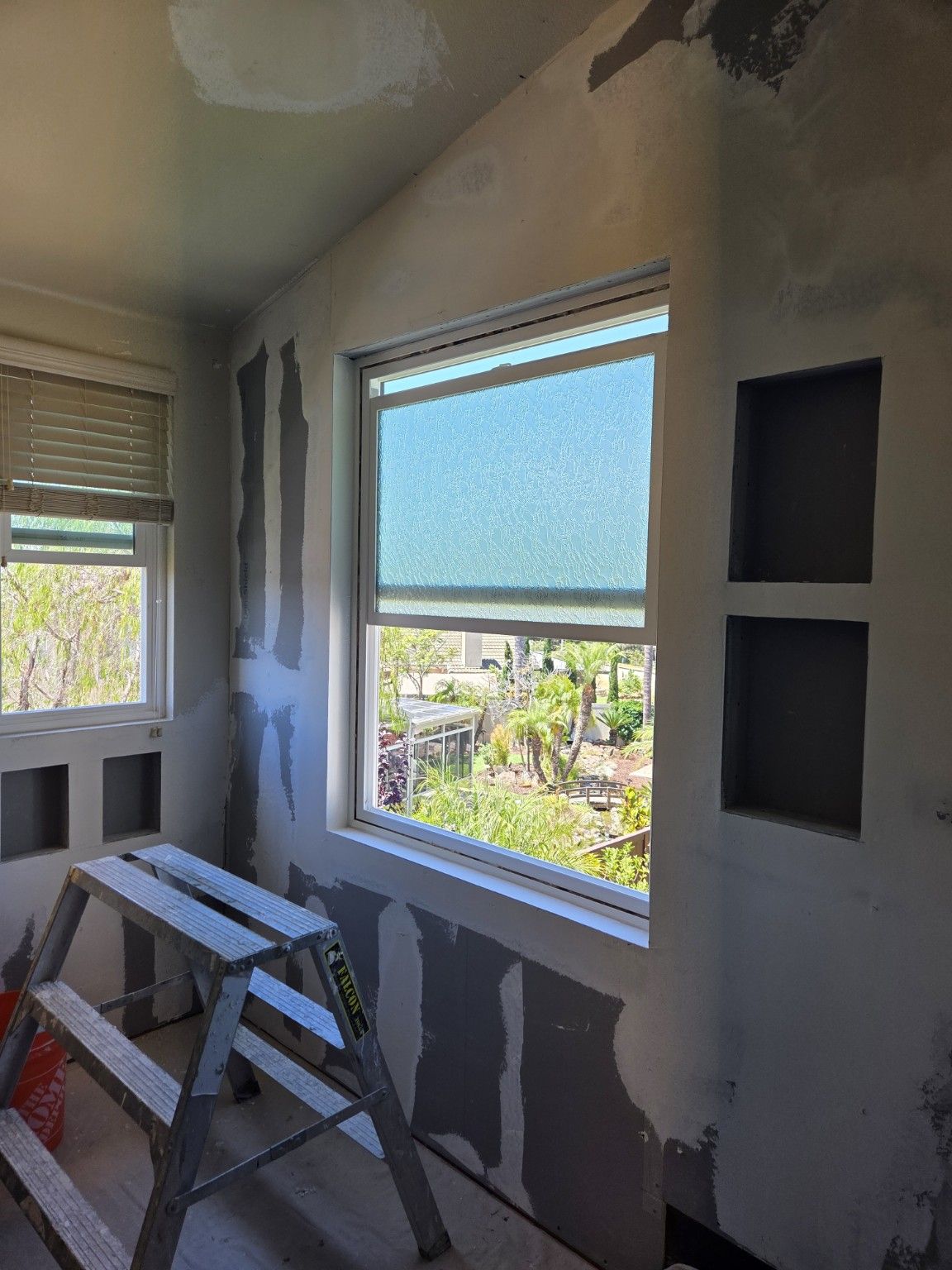 Bathroom wall joints and recessed niches being finished around the window.