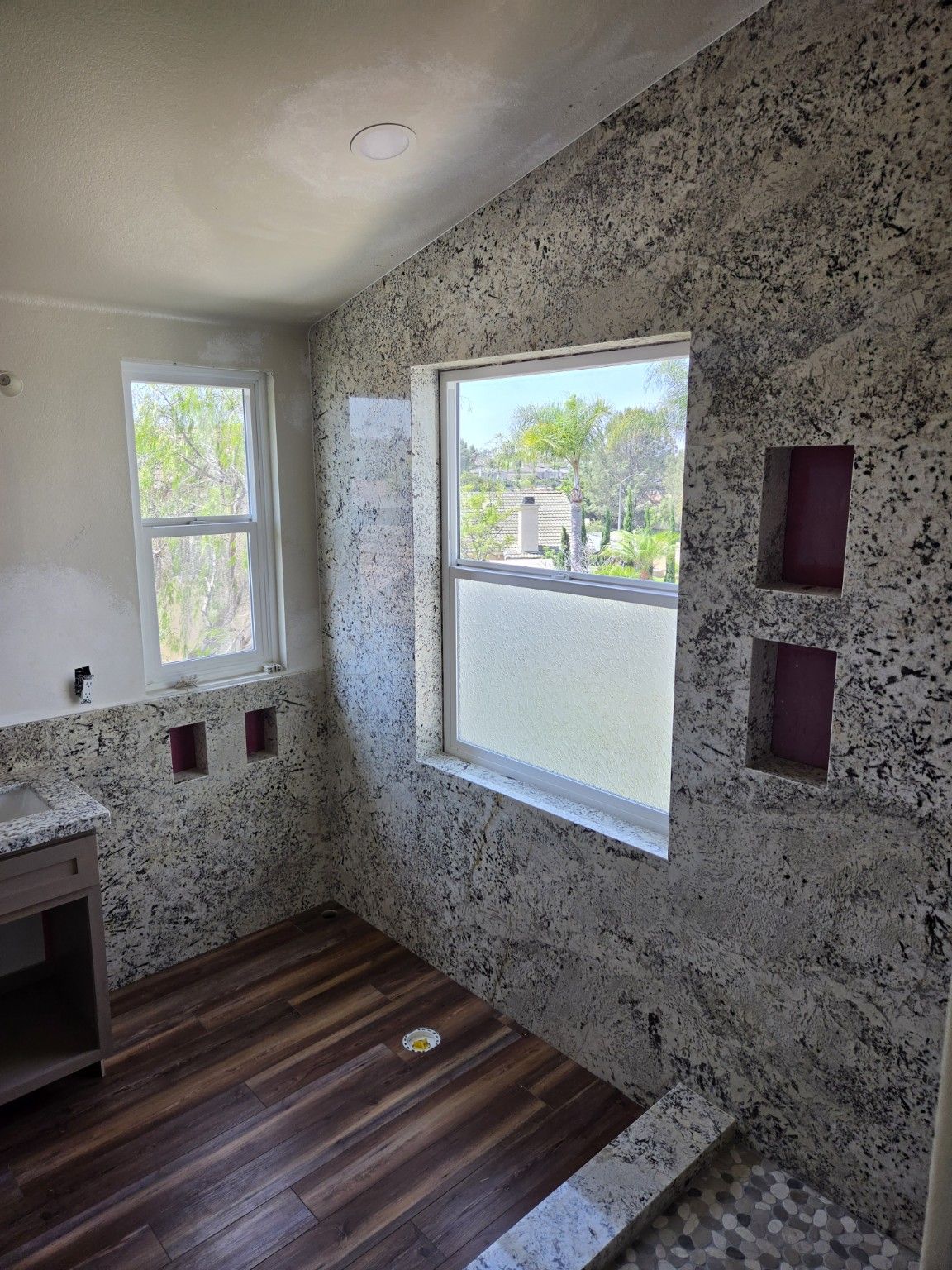 Speckled bathroom wall finish in place before tub, shower glass and fixtures are installed.