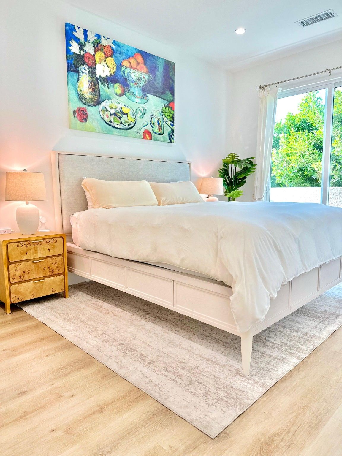 Bright bedroom with light flooring, recessed lighting and sliding glass doors