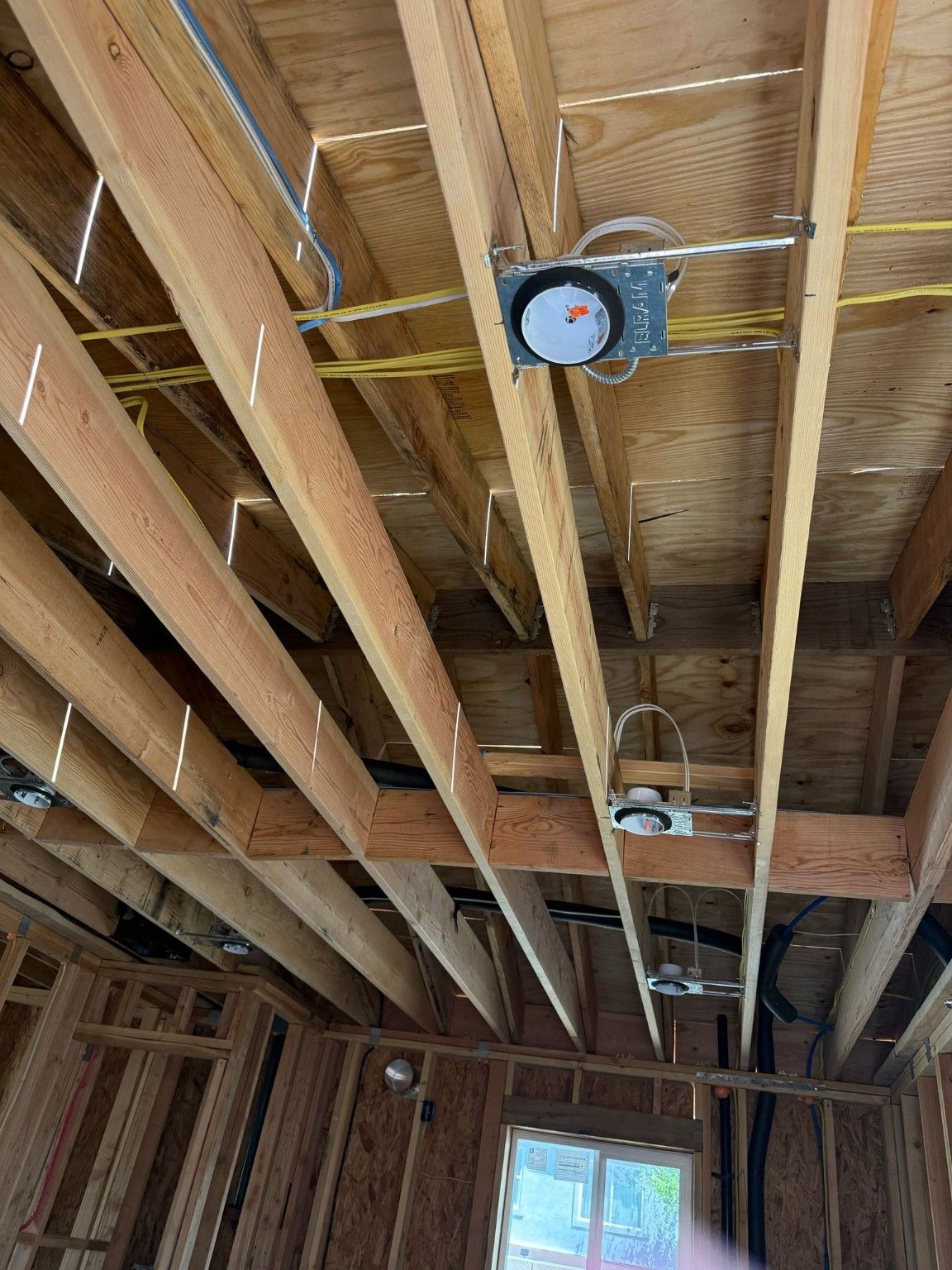 Exposed ceiling framing with wiring and fixture boxes