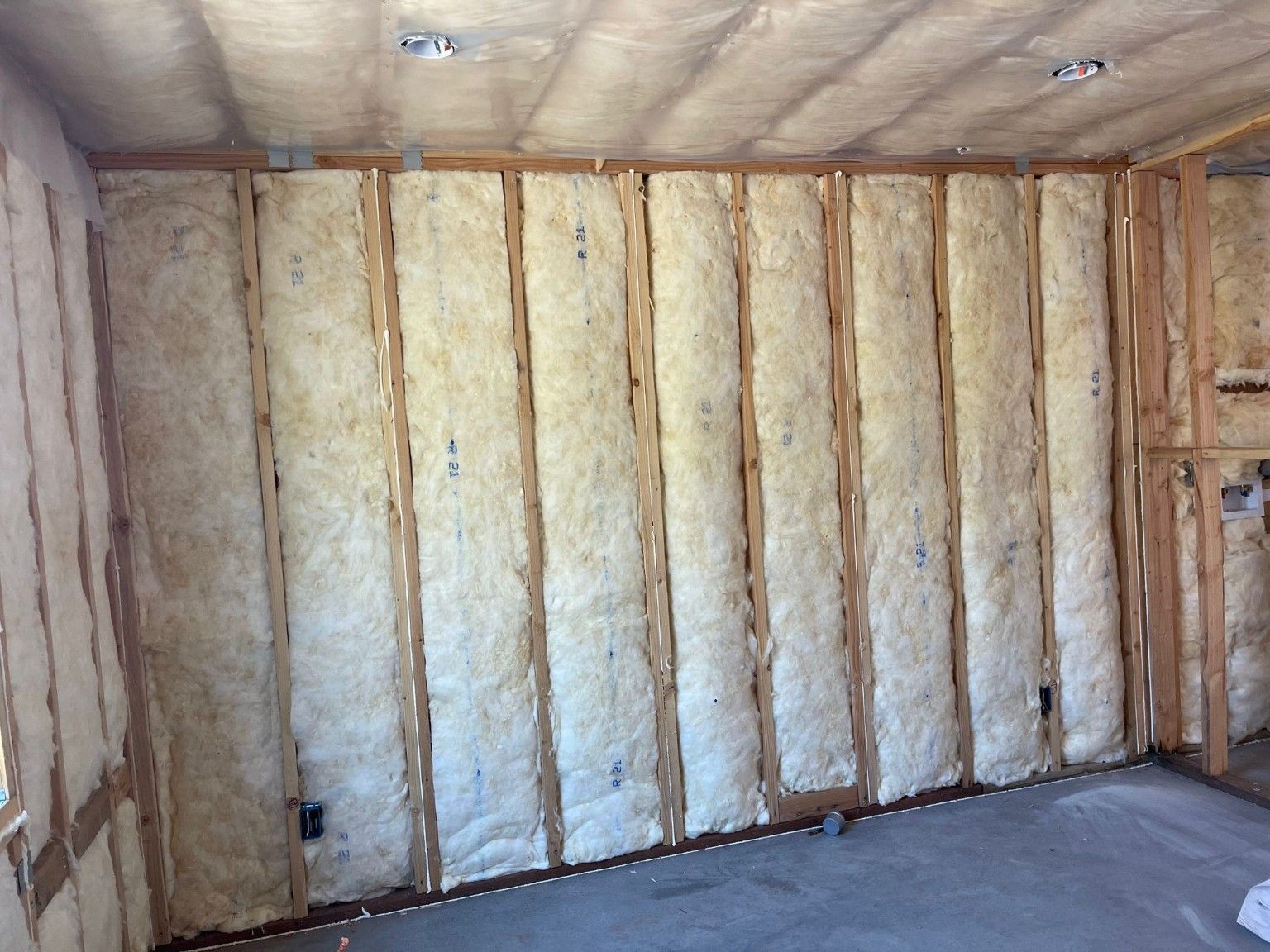 Long interior wall with insulation between exposed studs