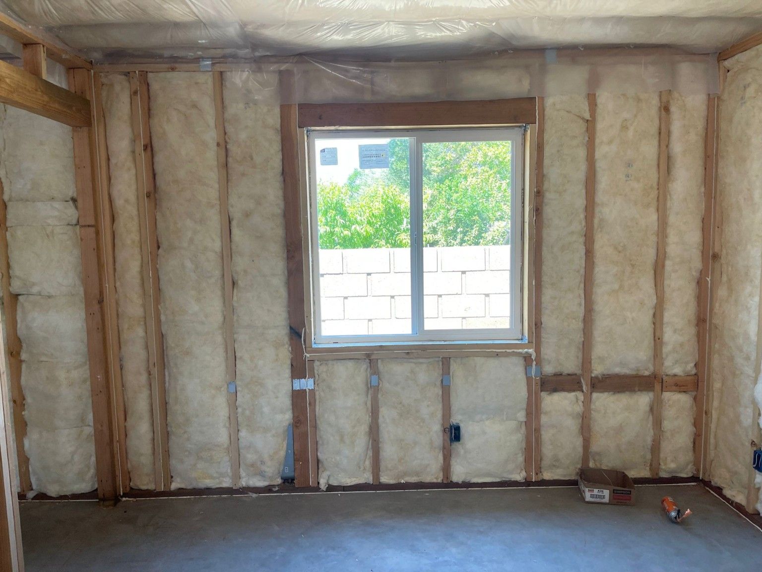 Insulation installed between wall studs around a window