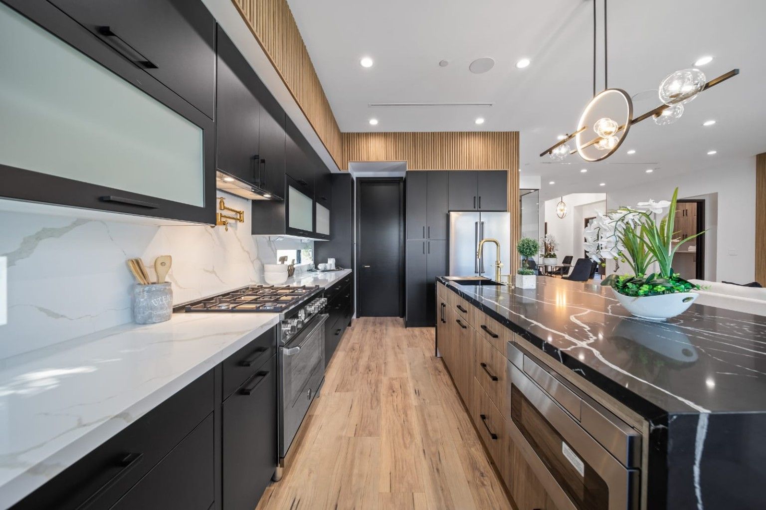 Dark kitchen cabinets, a range and light backsplash beside a wood island