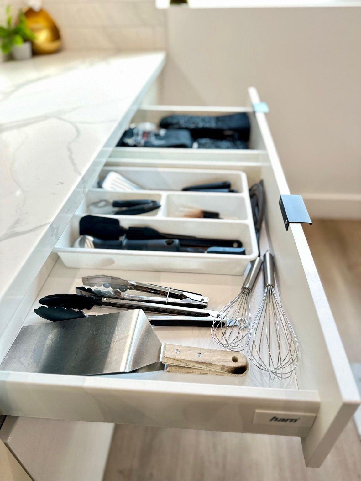 Open kitchen drawer showing organized cutlery and utensil compartments
