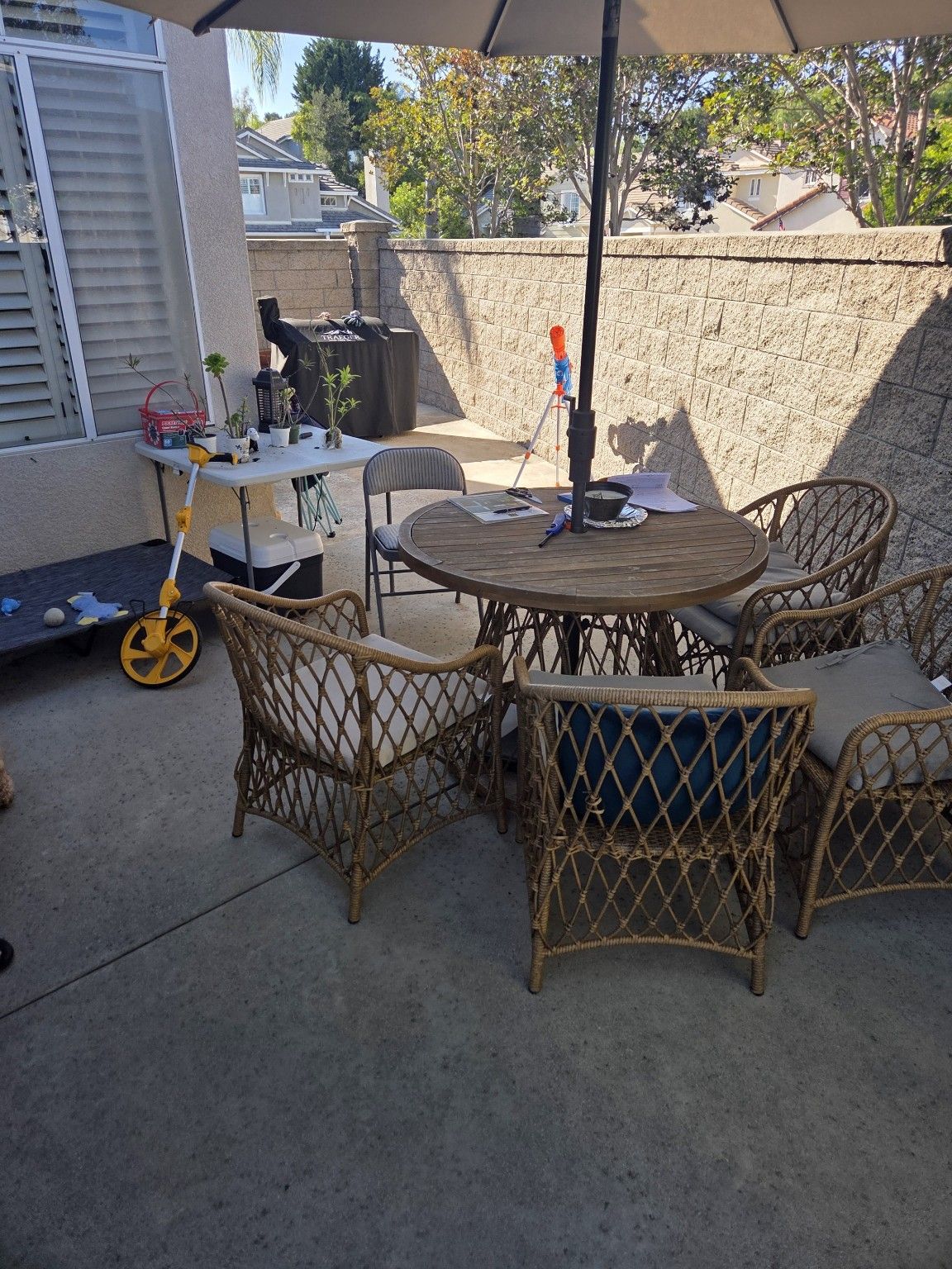 Outdoor table and chairs on a concrete patio beside the house