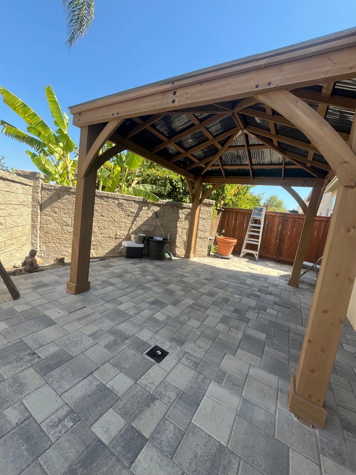 Gray paver patio beneath a wood outdoor cover