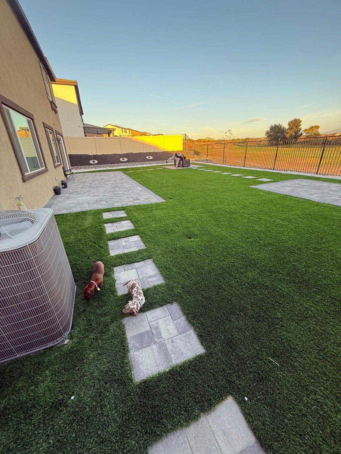 Stepping-stone path through artificial turf along the side of a house