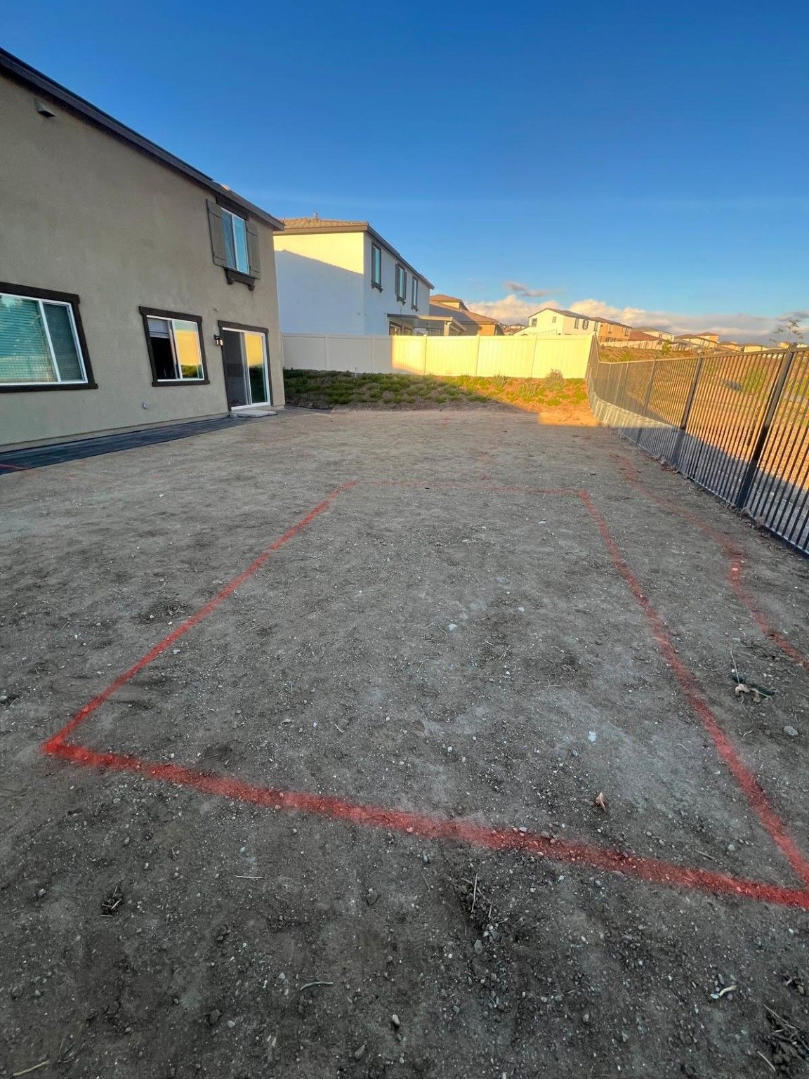 Yard with red layout markings beside the house